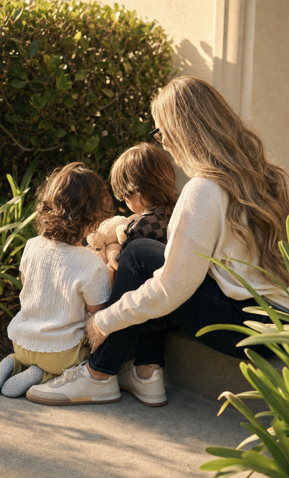 Liz Stone, founder and CEO of LizDev, Inc., sitting outdoors with her two children